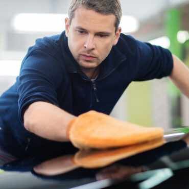 Man worker polishing car on a car wash